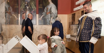 A dad plays dress up with one of his young daughters as the other is engrossed by an interactive in the main Civil War gallery